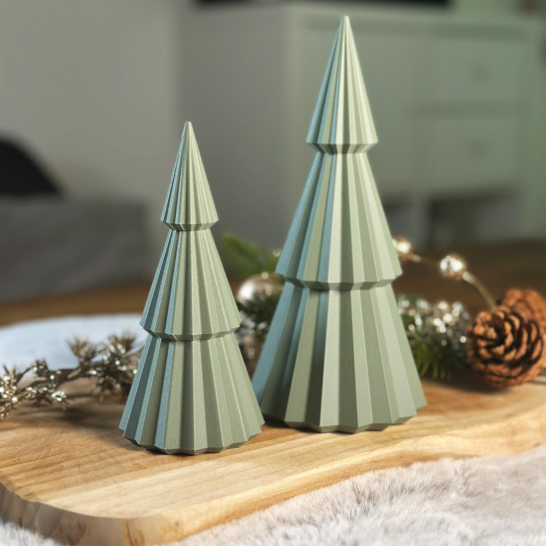Weihnachtsbaum Finn in einem zarten Hellgrün mit feiner Lamellenstruktur – moderne Winterdeko fürs Wohnzimmer. In zwei Größen erhältlich.