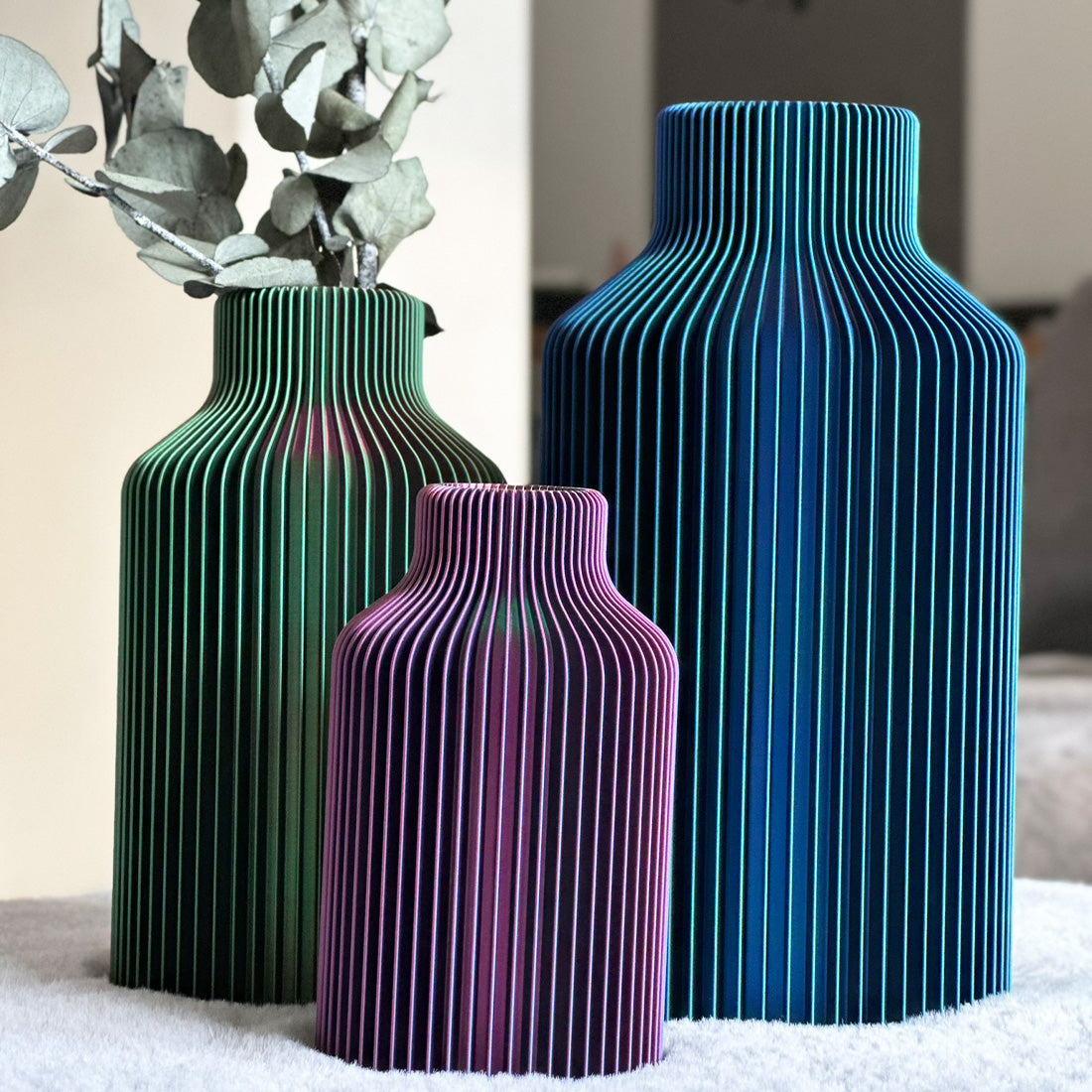 Vasen Hanna in der Farbe Tri-Color- Je nachdem in welchen Blickwinkel man die Vase hält schimmert sie in Rot, Blau und Grün mit Lamellenoptik.